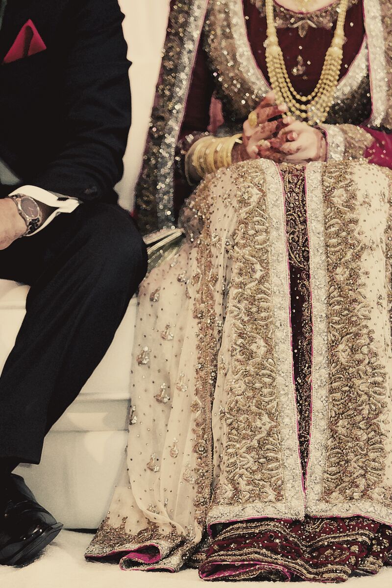 Bride in an ivory lehenga seated beside the groom
