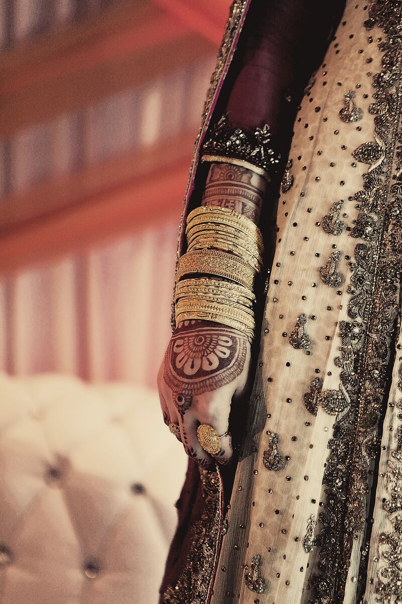 Stacked gold bangles against an embroidered lehenga