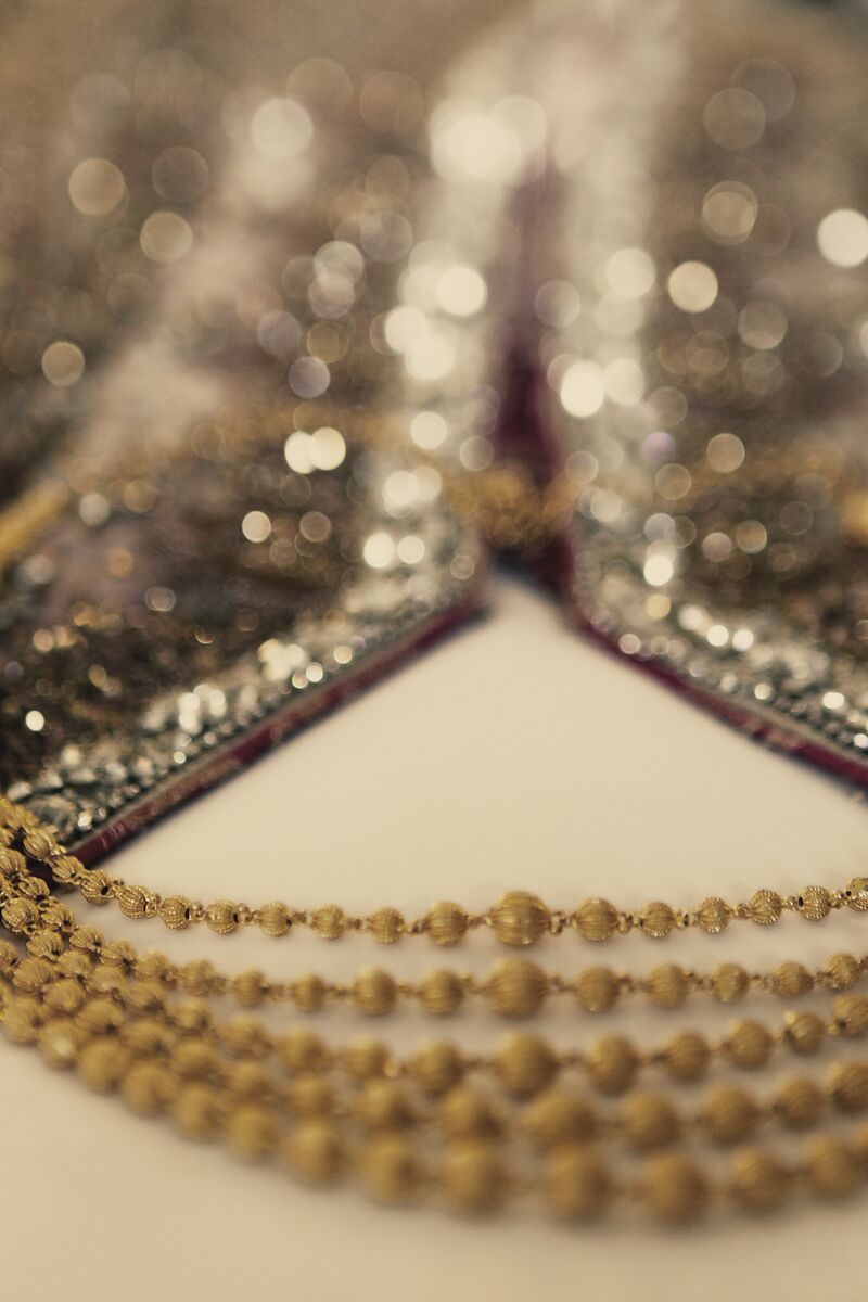 Gold bridal necklace laid on an embroidered neckline