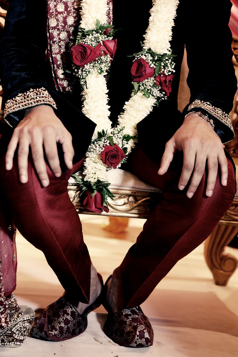 Groom seated in a rose garland at the baraat
