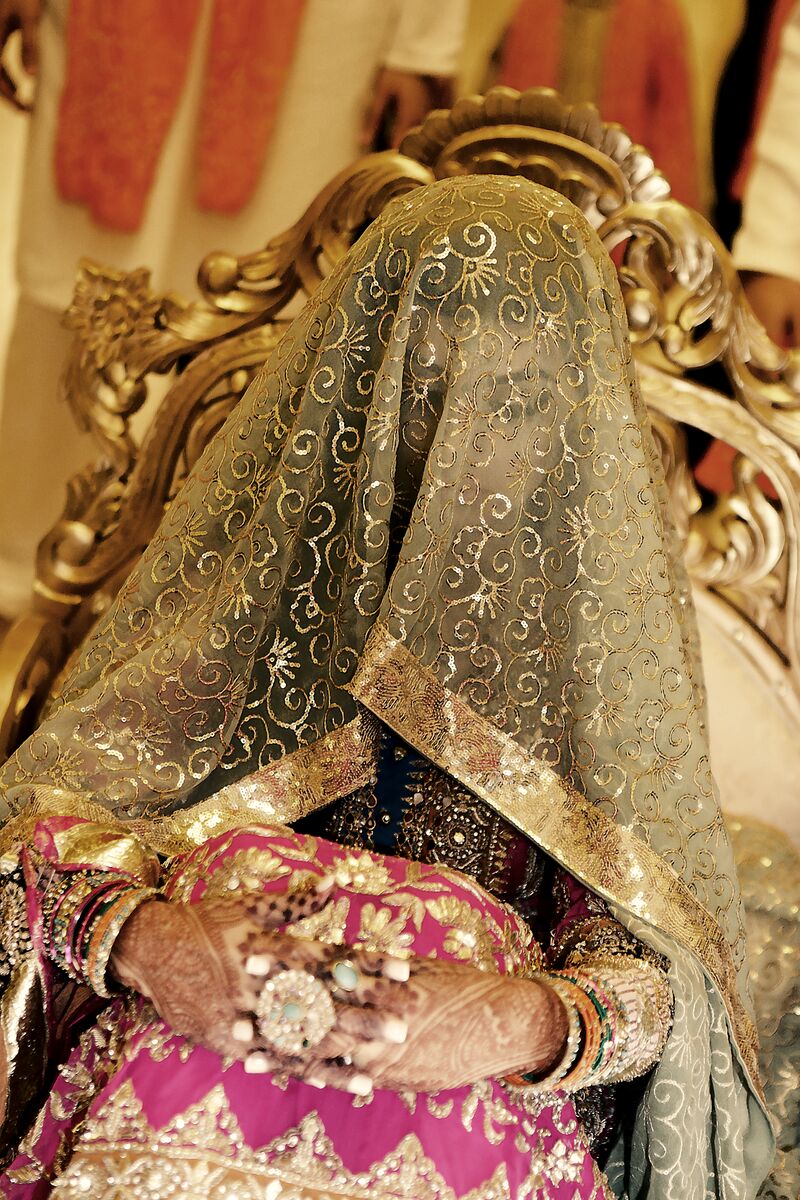 Bride beneath a gold veil on the nikkah stage